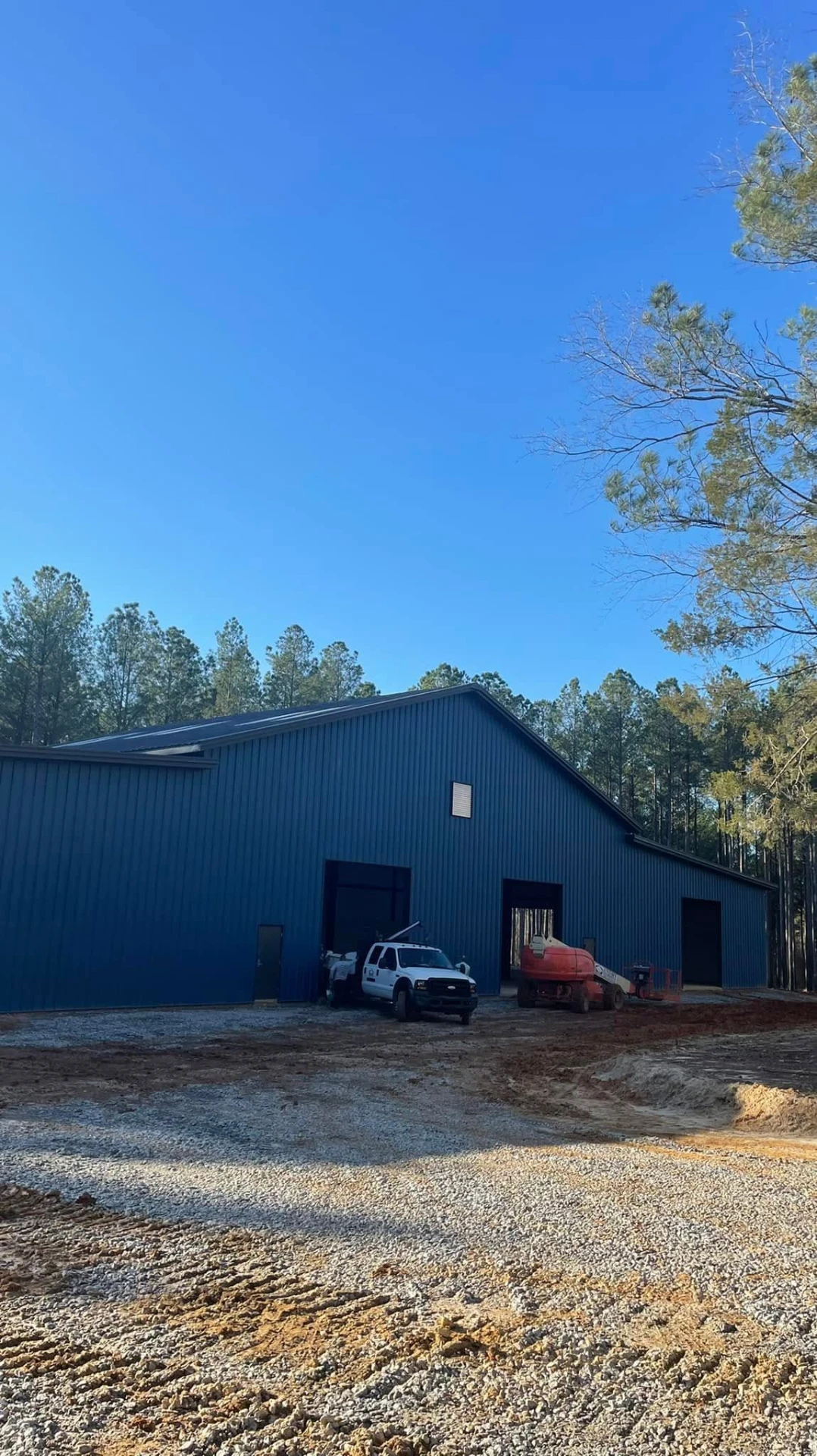 Completed horse barn exterior with roll-up doors