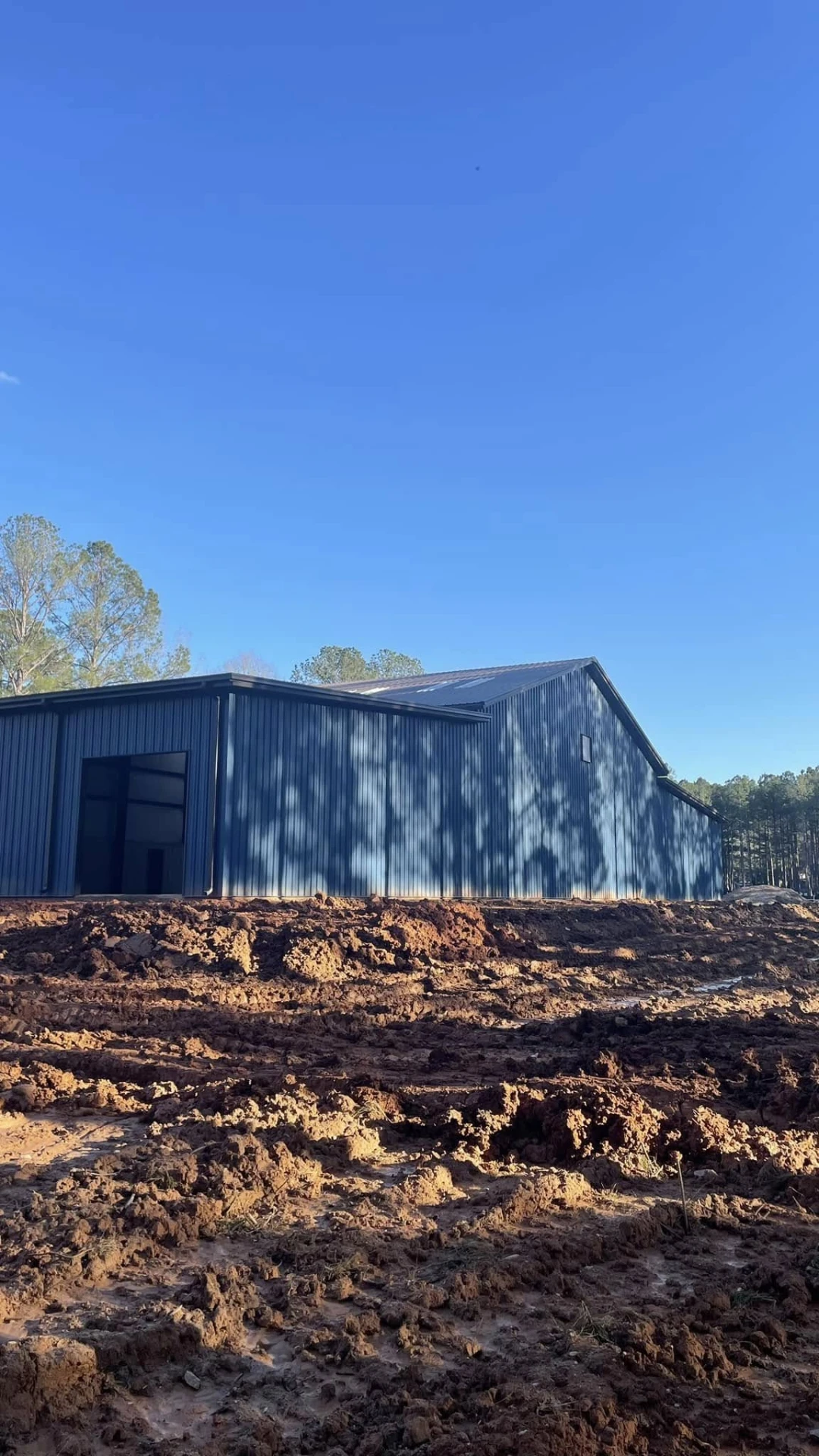 Horse barn with dark metal wall and roof panels installed